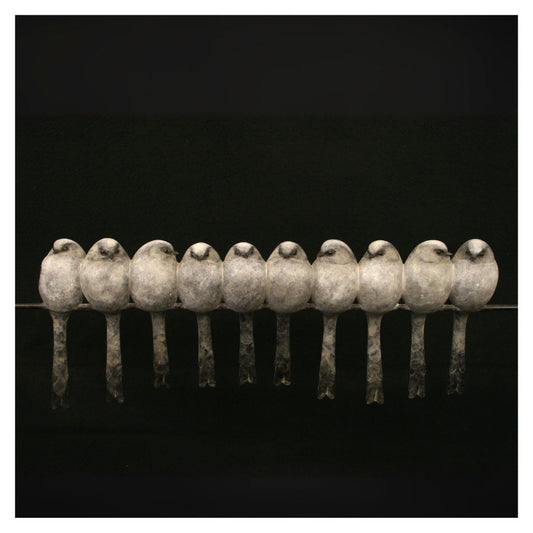 Row of stone birds perched on a wire against a black background
