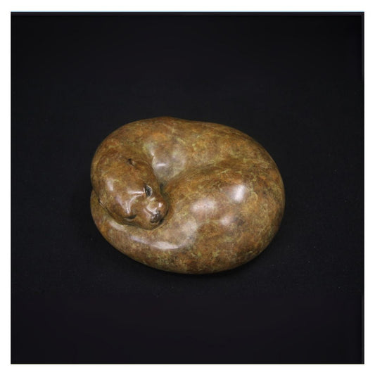 Brown stone sculpture of a cat on a black background