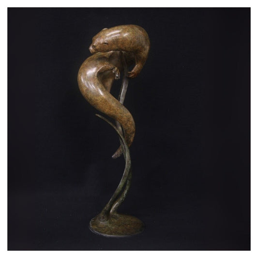 Bronze sculpture of a snake with a coiled body on a black background