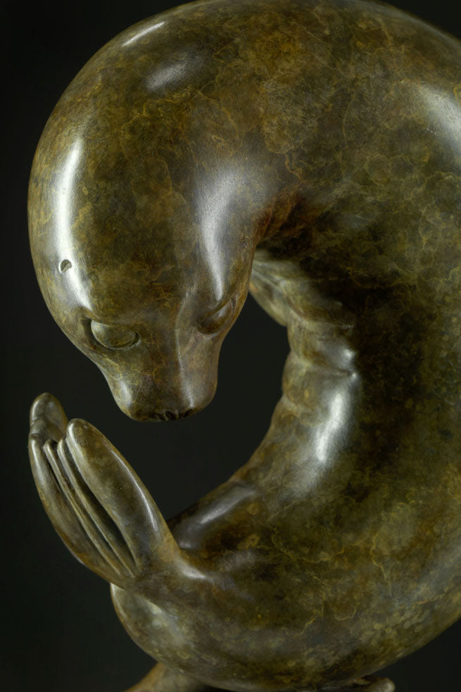 Bronze sculpture of a seal on a dark background