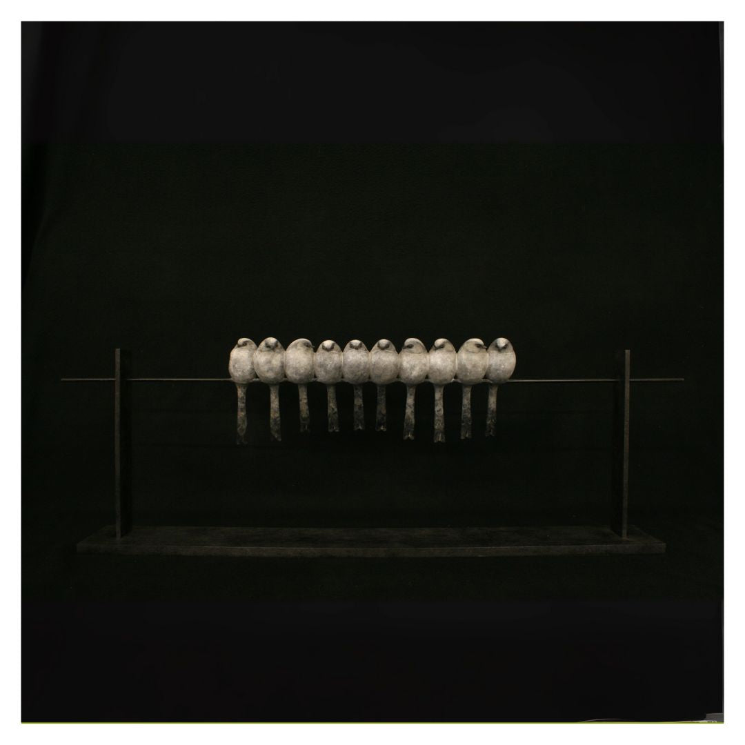 Row of metallic objects on a reflective surface against a black background