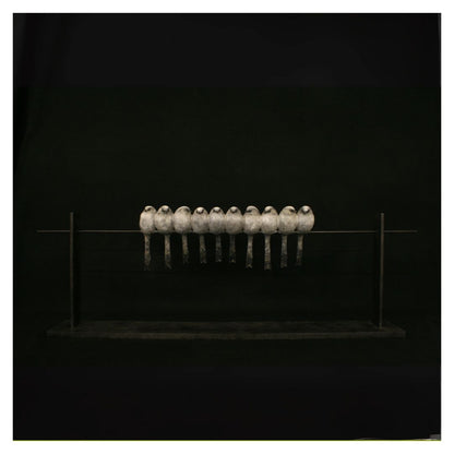 Row of metallic objects on a reflective surface against a black background