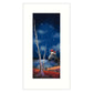 Framed artwork of a lighthouse on an island under a starry night sky with a tree in the foreground.