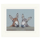 Mounted artwork of two donkeys peeking over a surface with a light blue background
