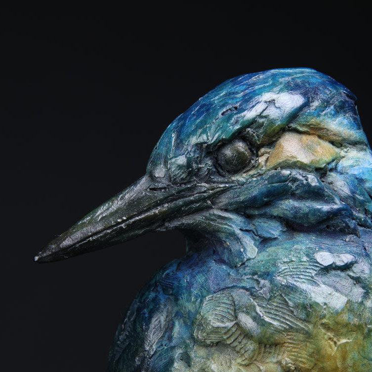 Close-up of a detailed sculpture of a kingfisher against a black background
