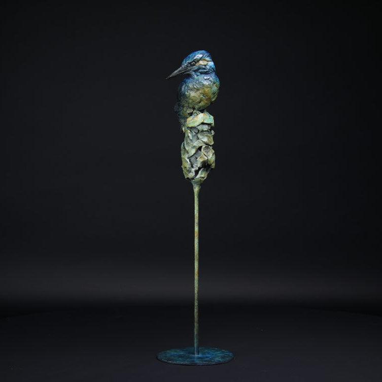 Bronze sculpture of a kingfisher on a black background