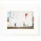 Framed artwork of a street scene with a child playing and a person walking a dog, featuring a red splash on a wall.