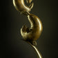 Bronze sculpture of two seals in a dynamic pose against a dark background